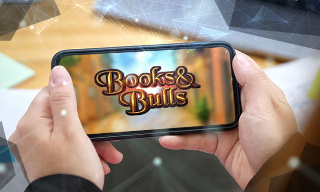 Der Schriftzug 'Books and Bulls' auf einem Smartphone, das ein Mensch in der Hand hält.