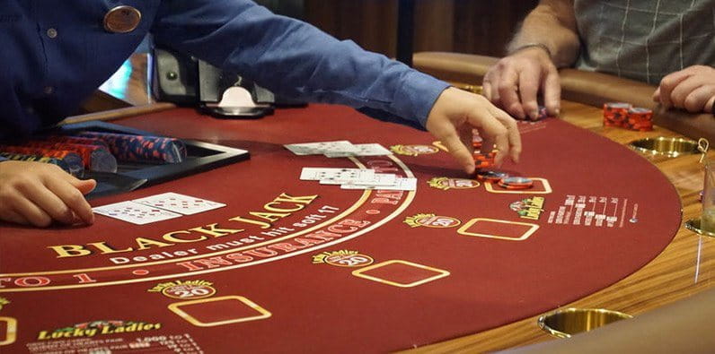 Ein Blackjack Dealer, der anzeigt, welche Hand im Spiel ist