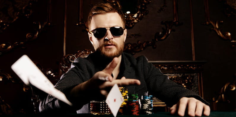 Mann spielt Karten an einem Casinotisch