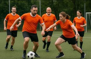 Eine Betreibssportgruppe, die sich auf dem Fußballplatz befindet und sich nach der Arbeit besser kennenlernen.